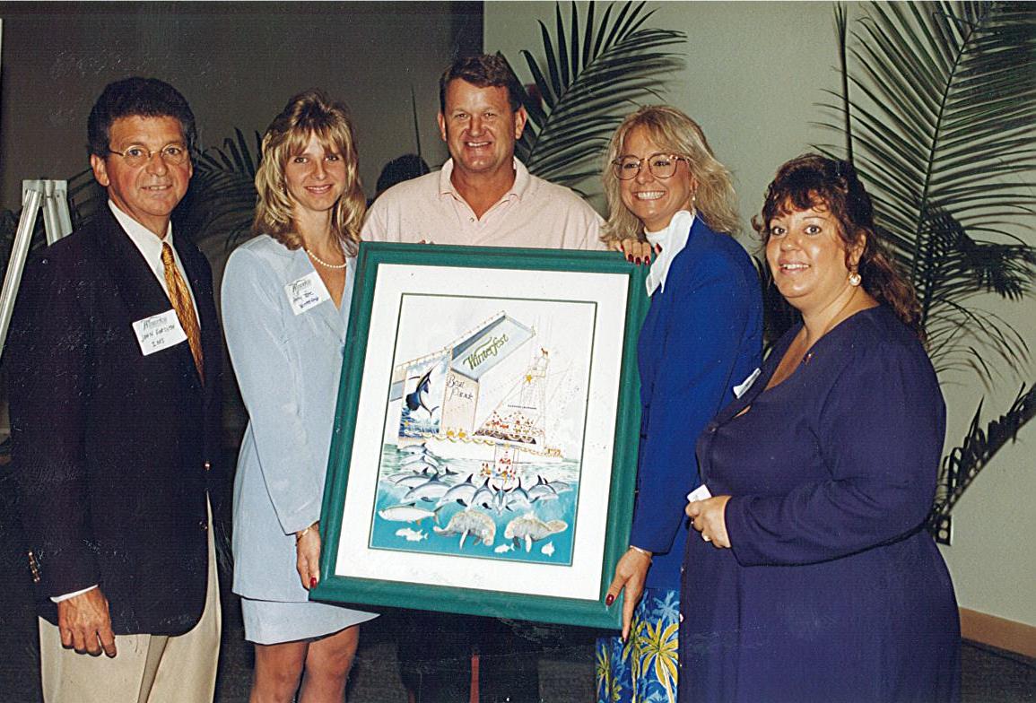 Artist Guy Harvey with Winterfest CEO Lisa Scott Founds revealing the 1998 parade poster