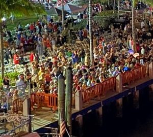 A crows of happy people watching The Seminole Hard Rock Winterfest Boat Parade from the Parade Viewing Area