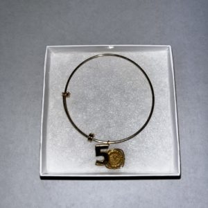 The Winterfest 50th Anniversary Commemorative Charm, gold colored 50th on a gold colored metal bracelet